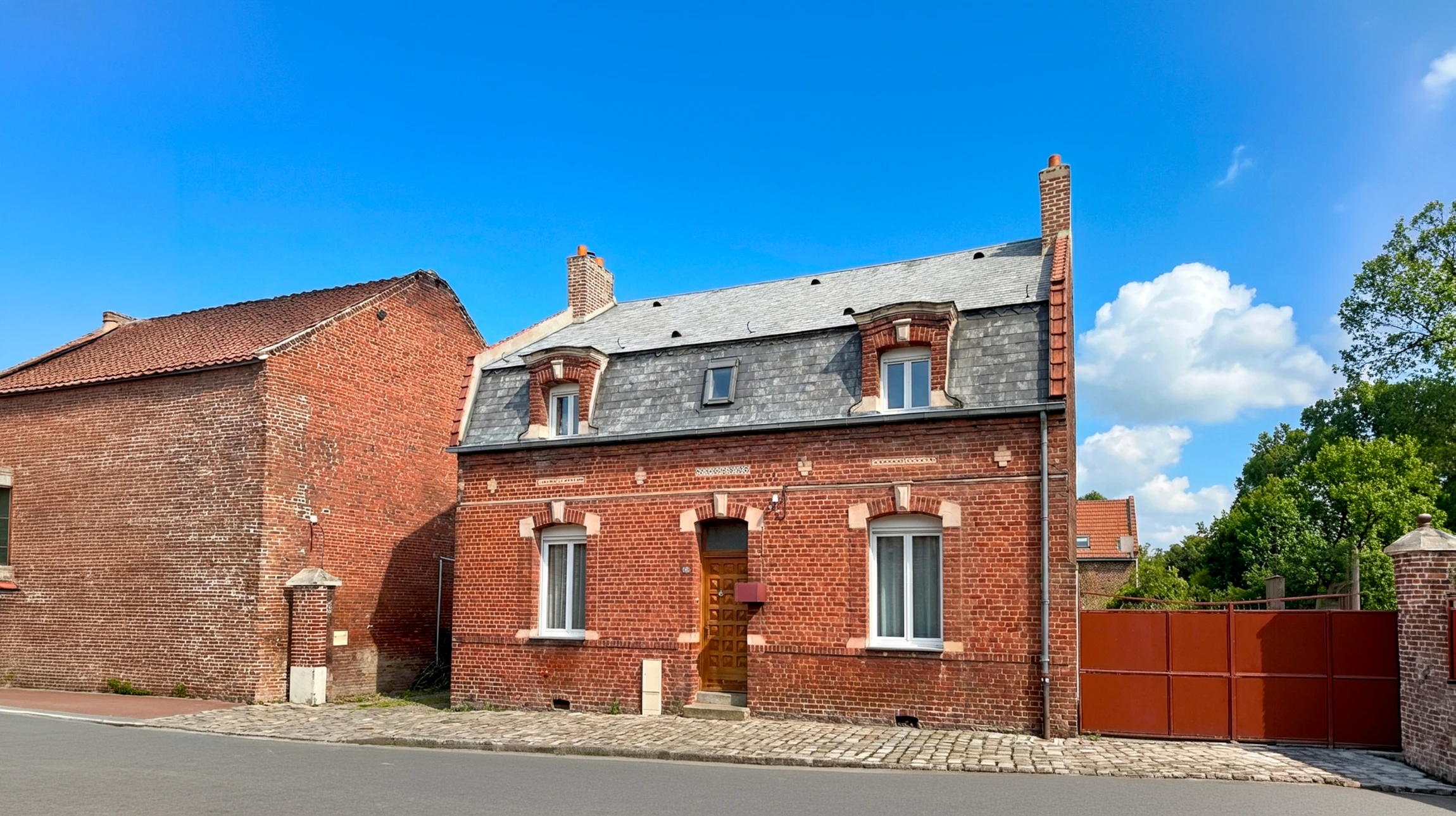 Toiture m&eacute;tallique moderne avec chemin&eacute;e en acier gris sous ciel nuageux au coucher du soleil, environnement r&eacute;sidentiel bois&eacute;